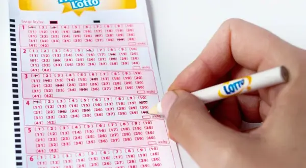Ręka zaznacza liczby na kuponie Mini Lotto. To kaskada zasady, gdzie każda kolejna linijka to szansa na wygraną.