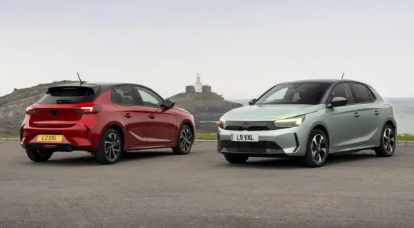 Dwa nowe modele Vauxhall Corsa, czerwony i zielony, stoją na tle morza i latarni morskiej.