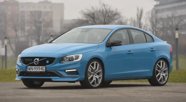 Błękitne Volvo S60 na tle budynków. Poznaj jego wymiary i możliwości.
