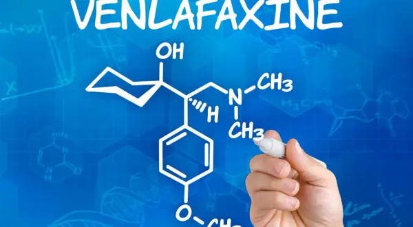 Rysunek chemiczny wenlafaksyny, leku znanego też jako velaxin, na niebieskim tle z wzorami chemicznymi.