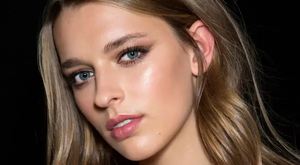 Piękna kobieta z niebieskimi oczami i subtelnym makijażem. Jej włosy, w odcieniach blondu i brązu, wyglądają jak naturalny flamboyage na krótkich włosach.