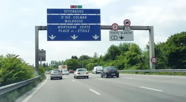 Sur l'autoroute A35, des panneaux indiquent Offenburg, Mulhouse et la Porte Blanche. Des voitures circulent par une journée nuageuse.