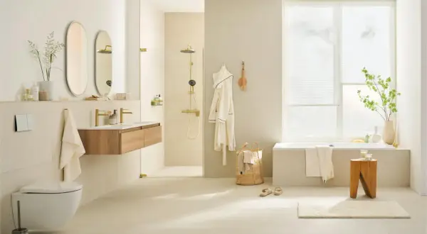 Modernes badezimmer braun creme mit freistehender Badewanne, Dusche, Waschtisch und Hänge-WC. Helle Fliesen und Holzakzente schaffen eine warme Atmosphäre.