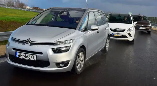 Srebrny Citroen Picasso, biały Opel Zafira i brązowy Volkswagen Touran jadą drogą. To najlepsze minivany na rodzinną podróż.