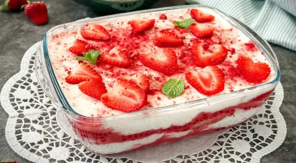 Erdbeer-Tiramisu ohne Ei, dekoriert mit frischen Erdbeerscheiben und Minze. Ein leichter Genuss für warme Tage.