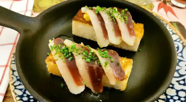 Deliciosos pinchos de jamón y pan tostado, perfectos para disfrutar en restaurantes con zona infantil en la Sierra de Madrid.