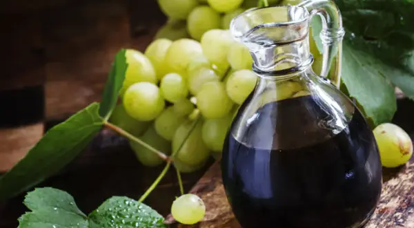 Ciemny płyn w karafce i winogrona. Szukasz, czym zastąpić ocet balsamiczny? Oto inspiracja.