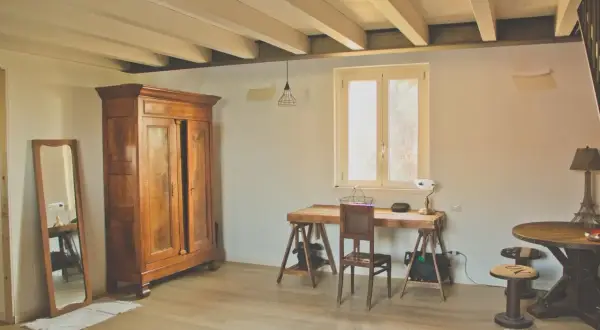 Arredare casa in campagna fai da te: armadio antico, scrivania rustica, specchio e lampada con base Torre Eiffel.