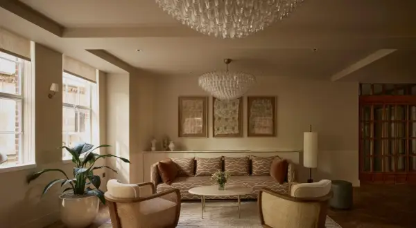 Ein Wohnzimmer im **lagom Lebensstil**: Gemütliche Sitzmöbel, dezente Farben, natürliche Materialien und Kunstwerke schaffen eine harmonische Atmosphäre.