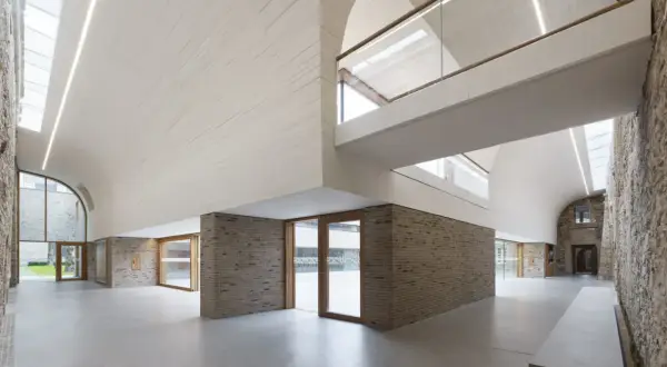 Modernes Haus Altenberg mit geschwungener Decke, Ziegelwänden und viel Glas.