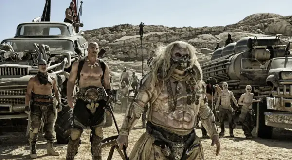 Postapokaliptyczne filmy sci-fi: Imperator Furiosa i jego wojownicy w pustynnym krajobrazie, otoczeni zmodyfikowanymi pojazdami.