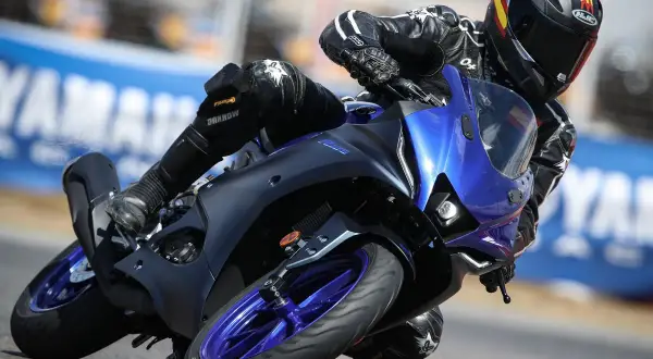 Piloto en Yamaha R125 azul inclinado en curva, demostrando su potencial de yamaha r125 top speed en pista.