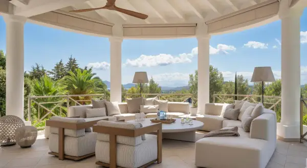 Cómodas terrazas modernas exterior con sofás modulares, sillones y mesa de centro, vistas a un paisaje verde y montañoso.