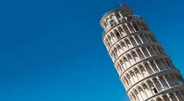 La Torre di Pisa dritta, un'illusione ottica sotto un cielo azzurro.