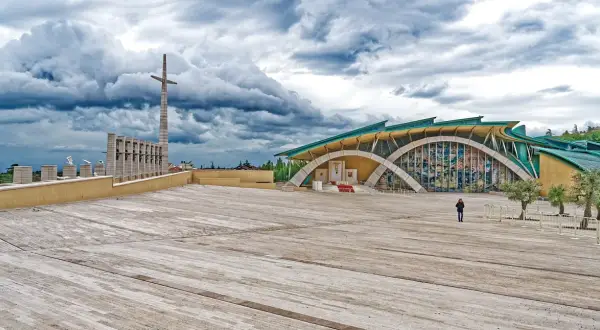 Piazza del Santuario di San Pio, il paese di Padre Pio, con la sua architettura moderna e il cielo drammatico.
