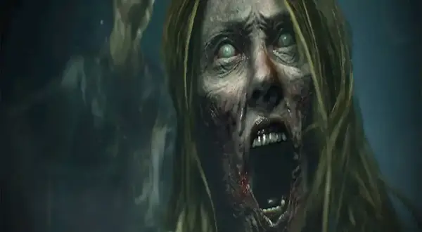 Przerażająca twarz zombie z zielonymi oczami i otwartymi ustami, w tle inny zombie. Scena jak z najlepszych filmów o zombie.