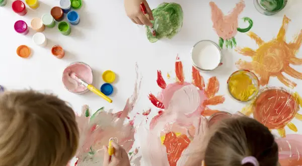 Niños pequeños creando arte con pinturas de colores. Soles, flores y mucha imaginación en esta actividad de arte para niños de 3 a 5 años.