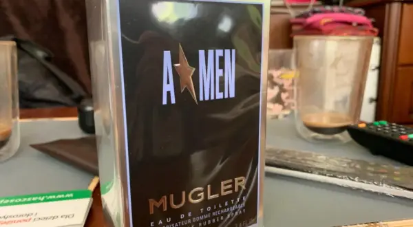 Pudełko perfum Mugler A*Men, zapach dla mężczyzny, w folii, na stole obok szklanki.