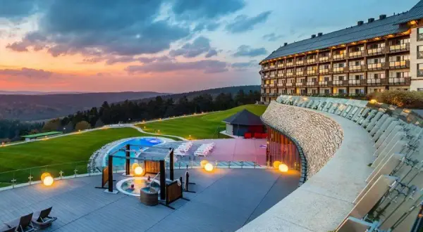Luksusowy hotel z basenem i jacuzzi na tarasie, otoczony zielenią i górami. Idealne miejsce dla szukających najlepszych hoteli w Polsce.