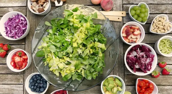 Salade colorée avec fruits et légumes. Les champignons, souvent considérés comme un aliment interdit pour tendinite, sont présents.