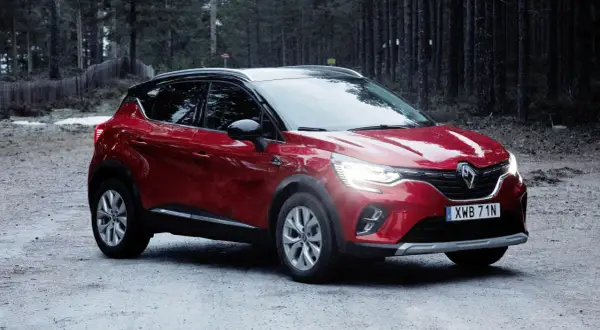Röd Renault Captur, redo för ett begagnat test i skogen.