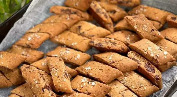 En hög med gyllene kolakakor med flingsalt, perfekta för fikat.