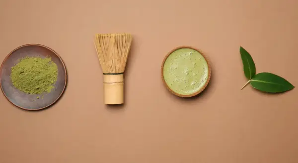Proszek matcha, bambusowa miotełka chasen, gotowy napój i liście. Czy matcha pobudza? Zobacz sam!