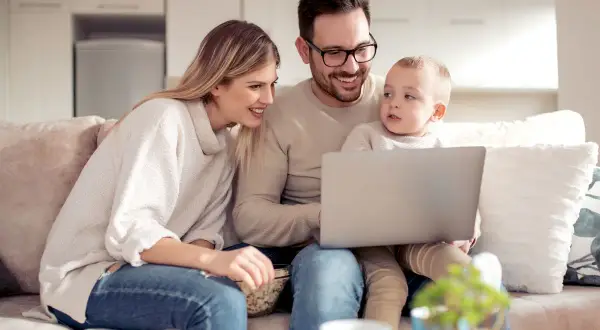 Rodzina ogląda coś na laptopie, zastanawiając się, czy 800 plus wlicza się do dochodu.