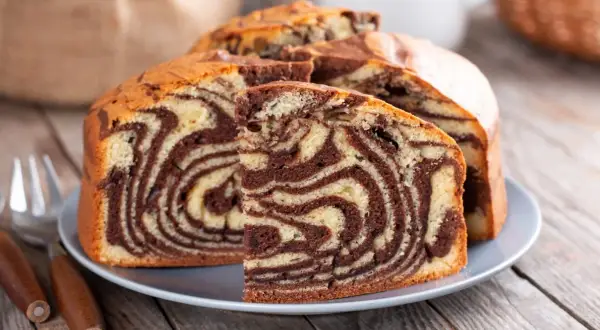 Pyszne niespotykane ciasta w paski zebry, pokrojone na talerzu, gotowe do degustacji.