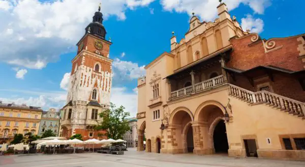 Wieża ratuszowa Kraków na Rynku Głównym, obok Sukiennic, pod błękitnym niebem.