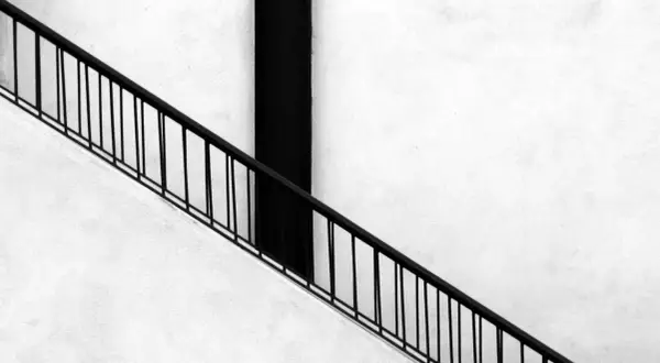 Ringhiera nera su muro bianco, un elemento essenziale per un montascale per anziani, agevolazioni per una vita più serena.