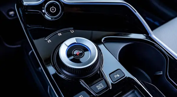 Pokrętło wyboru biegów w nowoczesnym samochodzie z napędem elektrycznym. Widoczny przycisk EV i oznaczenia R, N, D. Skrzynia biegów automat ułatwia jazdę.