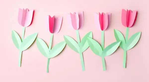 Fünf rosa Papier-Tulpen mit grünen Blättern, ein schönes Beispiel für blume basteln kinder.