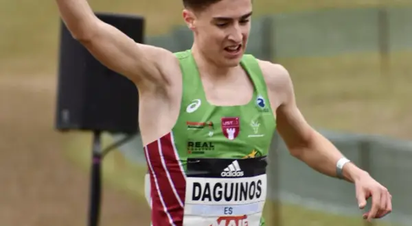 Le jeune athlète Etienne Daguinos, en pleine course, lève un bras victorieusement.