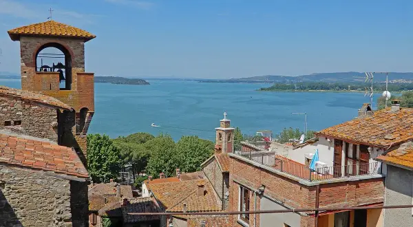 Vista panoramica di Passignano sul Trasimeno: campanile, tetti rossi e il lago azzurro. Ecco cosa vedere!