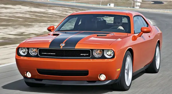 Pomarańczowy Dodge Challenger SRT na torze wyścigowym. Poznaj jego dodge challenger dane techniczne i poczuj moc!