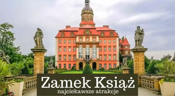 Zamek Książ, imponująca budowla z wieżą i rzeźbami, otoczona zielenią.