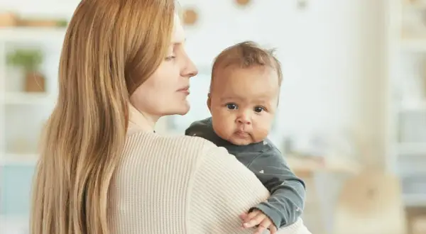 Mama tuli 4 miesięczne dziecko odchyla głowę do tyłu, patrząc z zaciekawieniem.