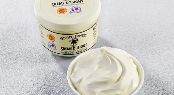 Crème d'Isigny : un pot et un bol de crème fraîche onctueuse. Parfaite pour la cuisine, sa richesse sublime vos plats.