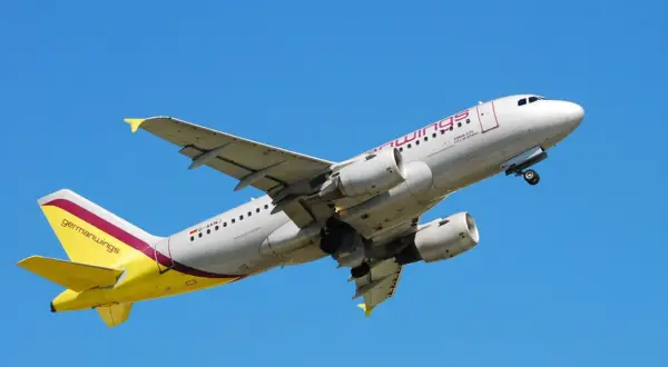 Samolot Germanwings z żółtym ogonem wznosi się na tle błękitnego nieba.