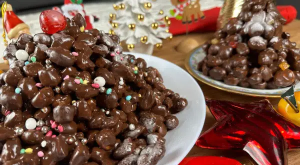 Deliziosi struffoli al cioccolato, decorati con zuccherini colorati e perline argentate, pronti per le feste natalizie.