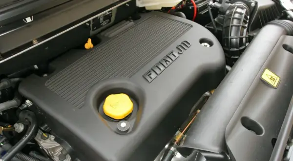 Silnik JTD Fiata z żółtym korkiem oleju i napisem FIAT JTD.