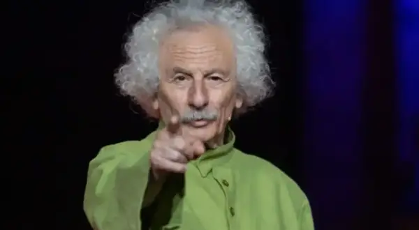 El brujo del Teatro de las Esquinas, con su melena blanca y camisa verde, señala al público.
