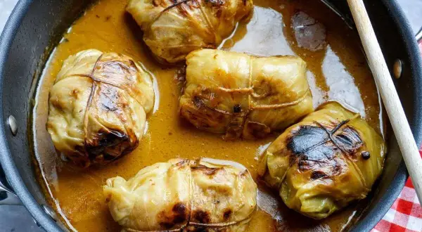 Fünf Kohlrouladen im Topf, bereit für ein köstliches Kohlrouladen Rezept.
