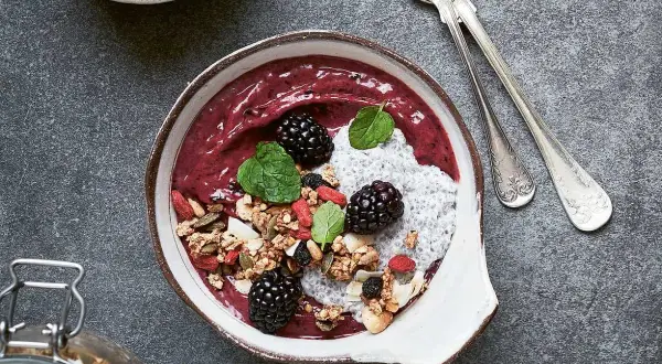 En läcker smoothie bowl med bär, granola, chiafrön och mynta. Perfekt för en hälsosam frukost eller mellanmål.
