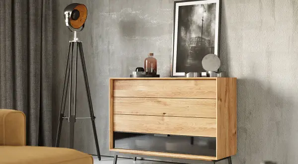 Szare ściany idealnie komponują się z beżowymi meblami, tworząc nowoczesne wnętrze. Komoda z litego drewna, lampa i obraz dodają charakteru.