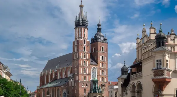 Majestatyczna Bazylika Mariacka w Krakowie góruje nad Rynkiem Głównym, gdzie tętni życie.
