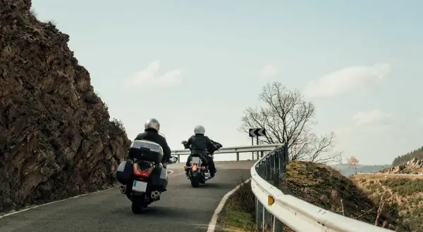 Dwaj motocykliści przemierzają malownicze trasy motocyklowe w Polsce, pokonując kręty górski asfalt.