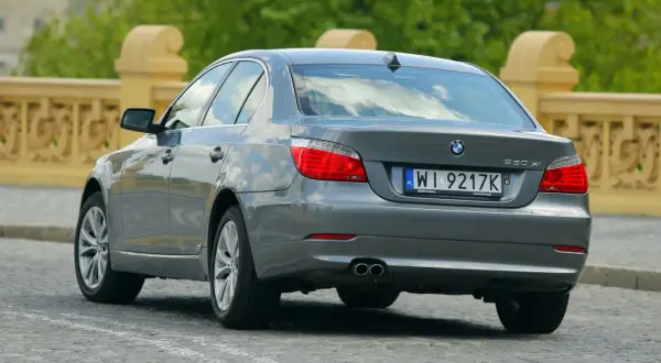 Szare BMW E60 530xi na brukowanej ulicy. Zastanawiasz się nad jego spalaniem?