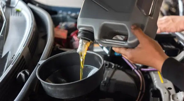 Persona vierte aceite de motor en un embudo. ¿Se puede mezclar aceite 5w30 y 5w40?
